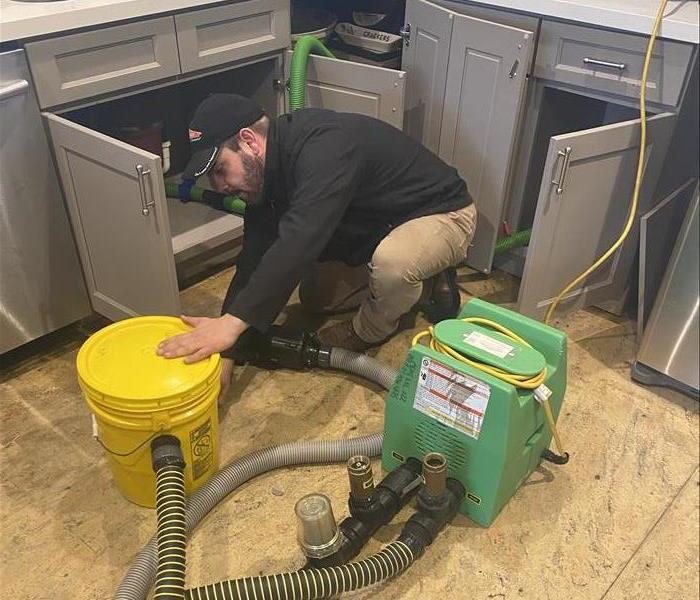 SERVPRO Crew member doing water restoration work on a residential property